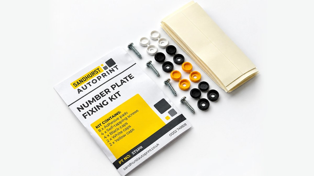 A Sandhurst Autoprint number plate fixing kit, with its packet beside the adhesive pads, self-tapping screws and black, white and yellow caps it contains